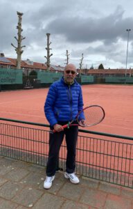 Een man met een tennisracket voor de smashcourt van TC Engelsbergen